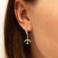 A close-up image of a person's ear wearing a gold-colored aviator-style earring with a jet charm.